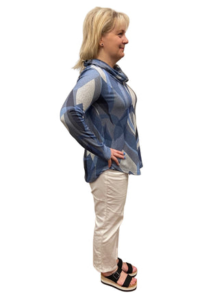 Person wearing a blue patterned jacket and white pants in a fitting room.