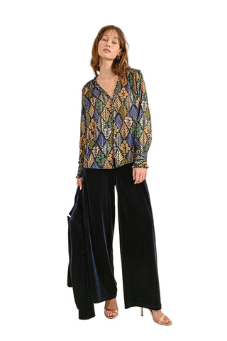A pair of high-waisted, black flowing velvet pants with marked pleats on the front and Italian pockets.