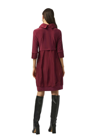 Woman wearing a burgundy dress with a white background