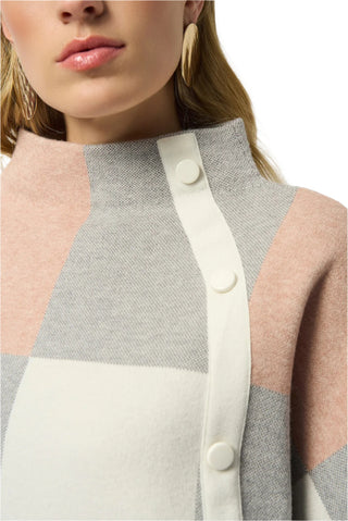 Close-up of a person wearing a patterned cardigan with pink, gray, and white colors.