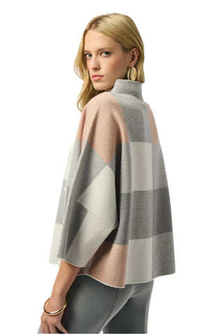 Woman wearing a checkered poncho on a white background