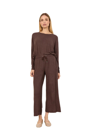 Woman wearing a brown outfit against a white background