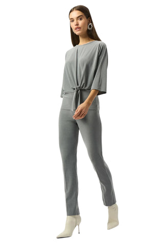 Woman wearing a gray jumpsuit on a white background