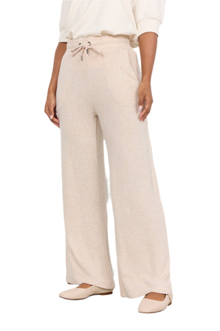 Person wearing beige drawstring pants on a white background