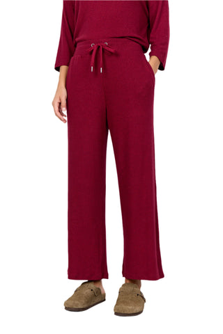 Person wearing a red outfit with wide-leg pants against a white background