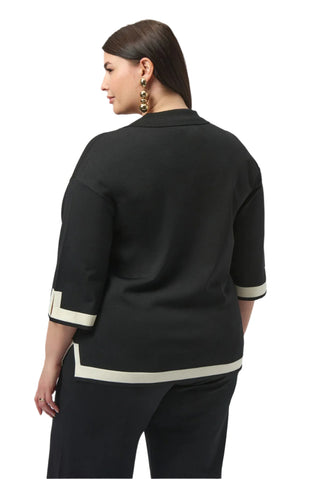 Woman wearing a black outfit with white trim on a white background