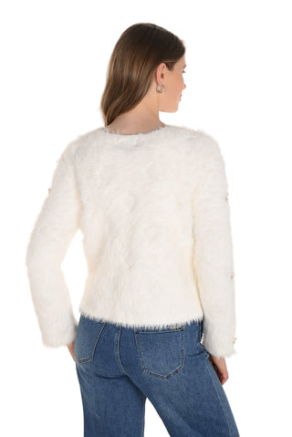Woman wearing a white fluffy sweater and blue jeans on a white background