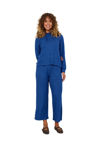 Woman wearing a blue outfit standing against a white background