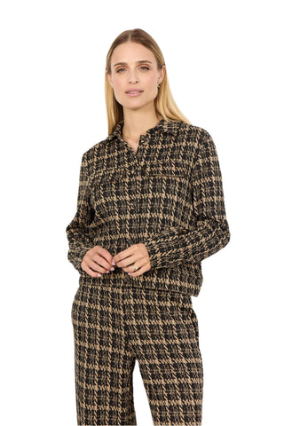 Woman wearing a houndstooth patterned outfit on a white background