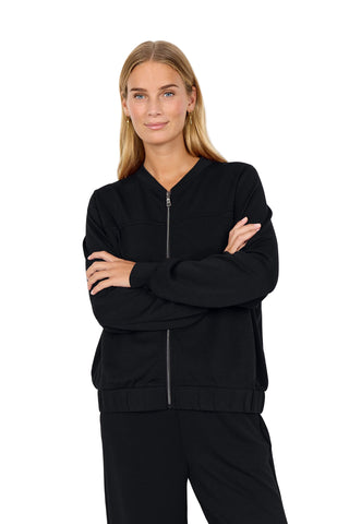 Woman wearing a black tracksuit against a white background