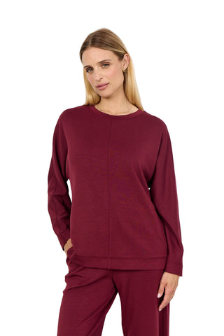 Woman wearing a burgundy outfit on a white background