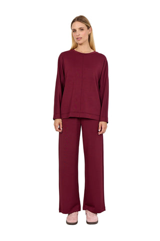 Woman wearing a burgundy outfit against a white background