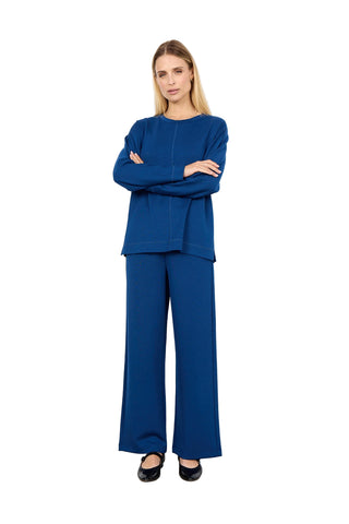 Woman wearing a blue outfit standing against a white background