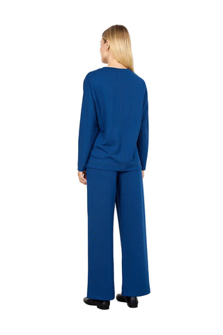 Woman wearing a blue outfit standing against a white background