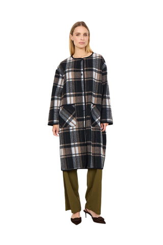 Woman wearing a plaid coat and green pants against a white background