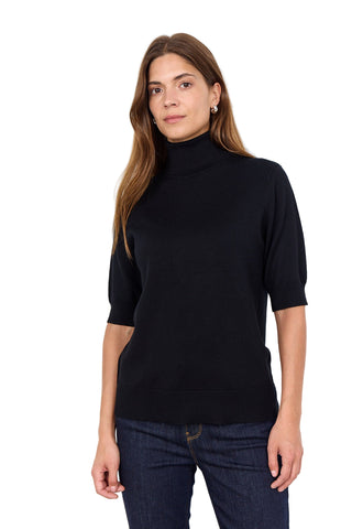Woman wearing a black turtleneck sweater against a white background