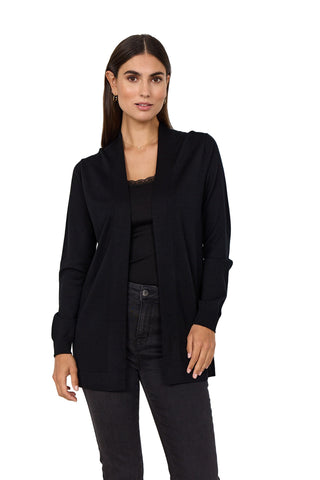 Woman wearing a black cardigan over a black top and jeans on a white background
