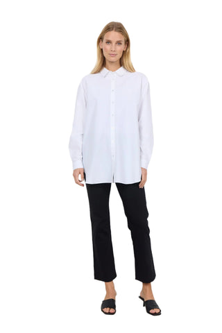 Woman wearing a white shirt and black pants against a white background