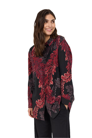 Woman wearing a black and red floral patterned shirt against a white background