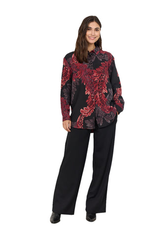 Woman wearing a black floral jacket and black pants on a white background