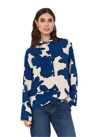 Woman wearing a blue and white floral blouse against a white background