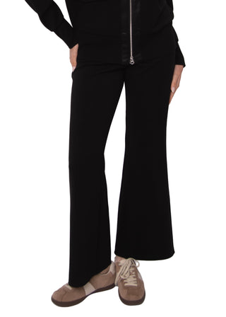 Person wearing black pants and a black jacket on a white background