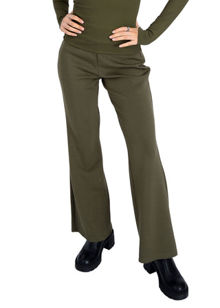 Person wearing olive green flared pants and a matching top on a white background