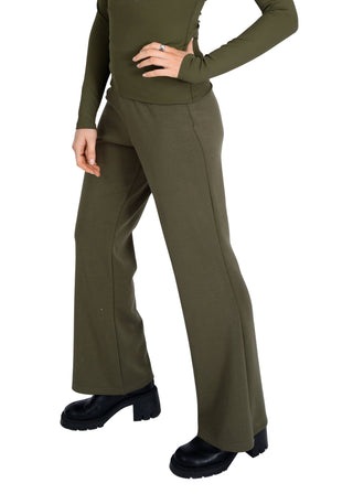 Person wearing olive green pants and top on a white background