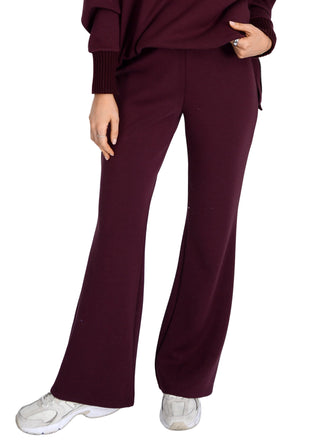 Person wearing a burgundy outfit with wide-leg pants on a white background