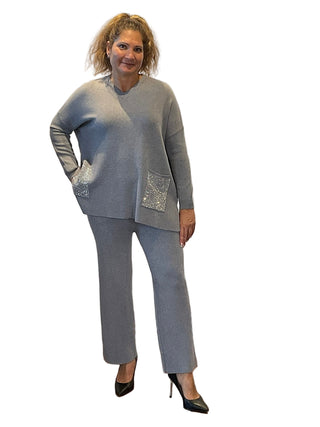 Woman in a gray outfit standing in front of an 'Anne's on the Avenue' backdrop.