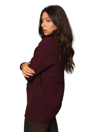 Woman wearing a burgundy sweater against a gray background