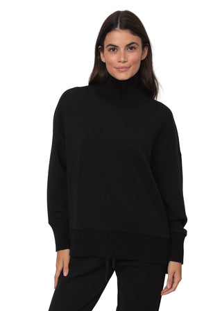 Woman wearing a black turtleneck sweater against a white background