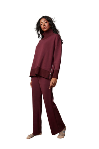Woman wearing a maroon outfit against a brown background