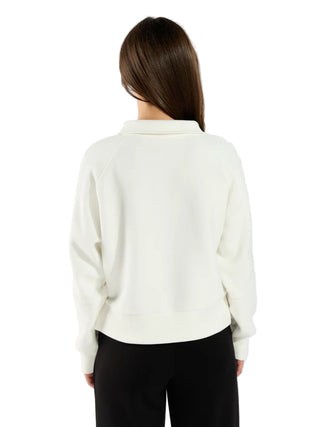 Person wearing a white blouse with long sleeves on a plain background