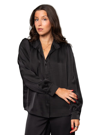 Woman wearing a black blouse against a gray background