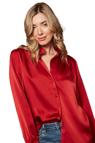 Woman wearing a red satin shirt against a brown background
