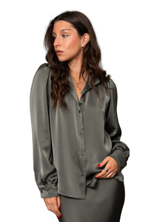 Woman wearing a gray blouse against a gray background