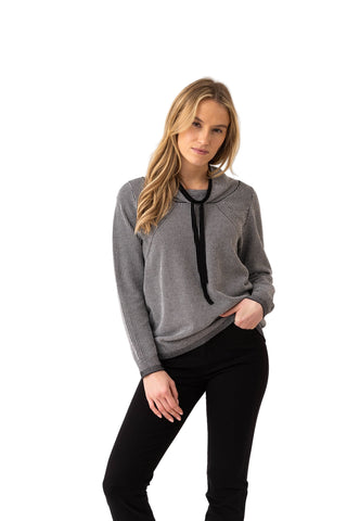 Woman wearing a gray sweater with a black drawstring on a white background