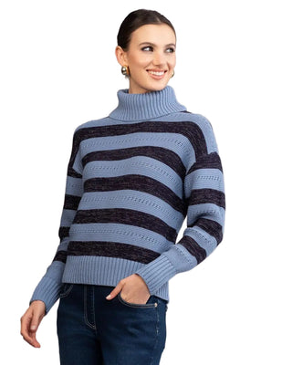 Woman wearing a blue and black striped sweater against a plain background