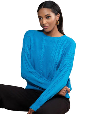 Woman wearing a blue sweater sitting on a beige couch.