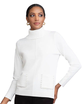 Woman wearing a white turtleneck sweater against a gray background