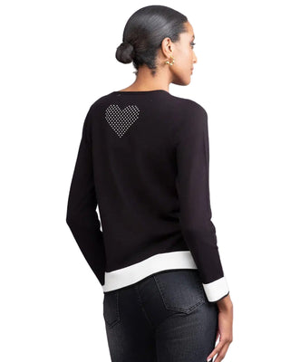 Black sweater with a heart pattern on the back worn by a person, against a plain background