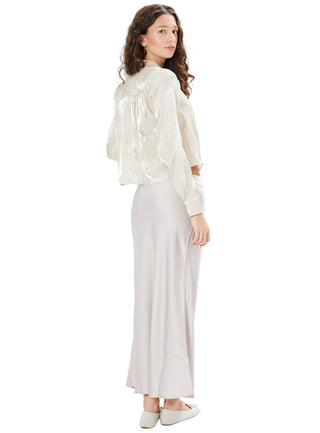 Woman wearing a white blouse and light-colored pants on a white background