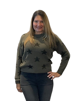 Woman wearing a green sweater with star patterns against a white background