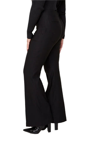 Person wearing black flared pants on a white background