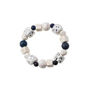 Beaded bracelet with white, black, and blue beads on a light gray background