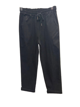 Black pants on a hanger against a white background