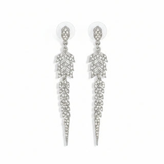 Pair of silver leaf-shaped earrings on a textured brown surface