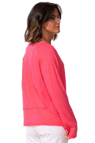 Woman wearing a pink long-sleeve top on a white background
