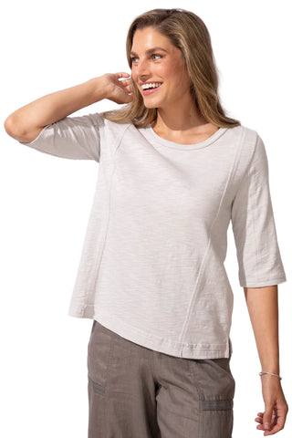 Woman wearing a light gray top and dark gray pants on a white background